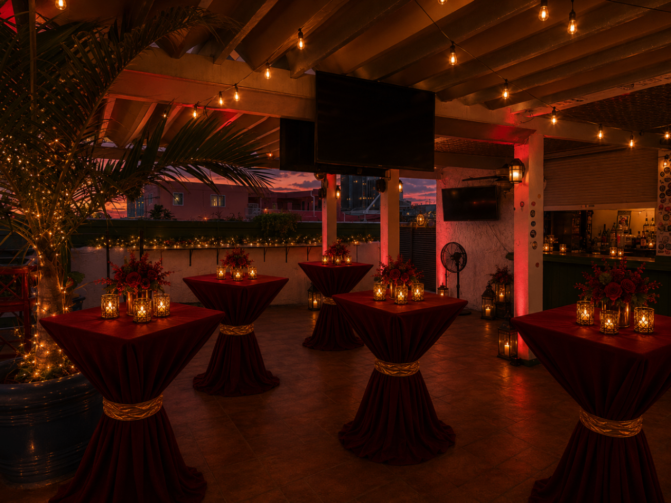 Moody lounge-side Scarlett Soirée scene with palms, lanterns, and red-draped high-top tables